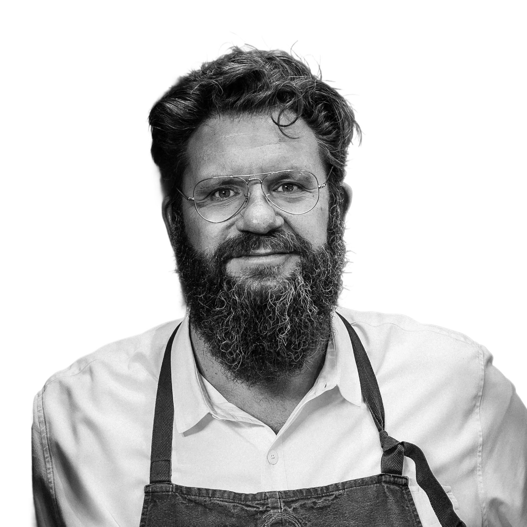 Black and white portrait of a bearded man wearing eyeglasses and an apron.