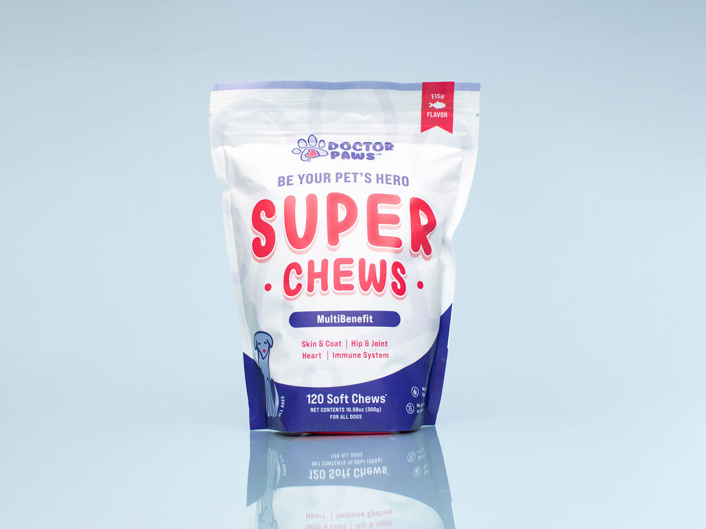 A white and blue pouch of Doctor Paws Super Chews dog treats sitting on a reflective surface.