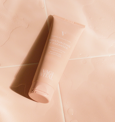 Tube of moisturizing cleanser on wet tiles.