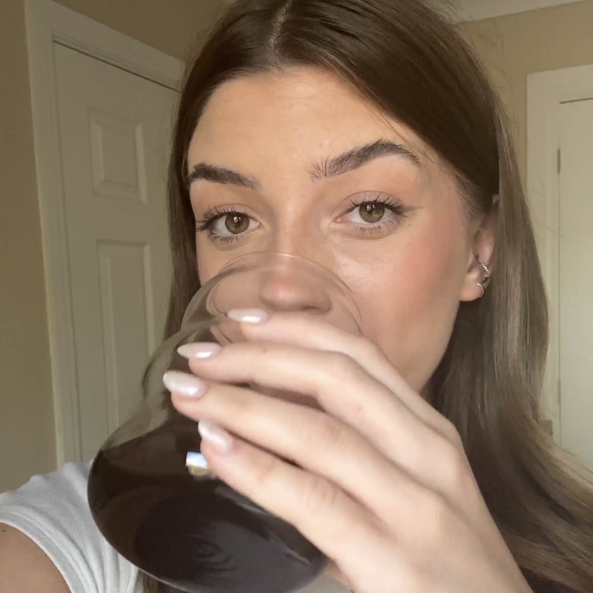 Person drinking from a glass, close-up view.