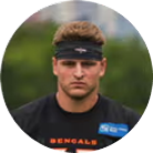 A circular headshot of a young male football player wearing a black headband and a Bengals jersey.