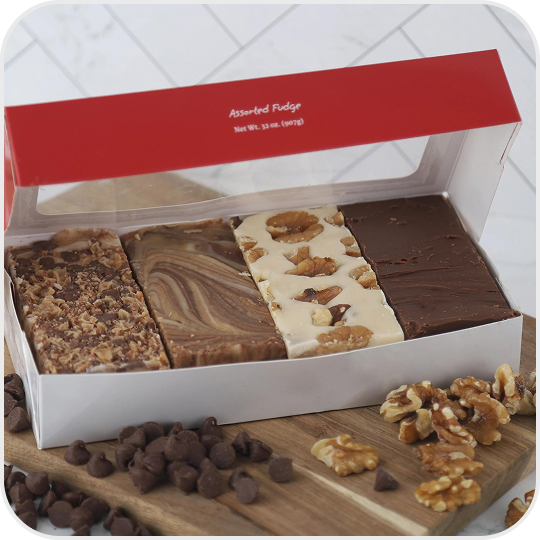 Box of assorted fudge with chocolate chips and walnuts beside it.