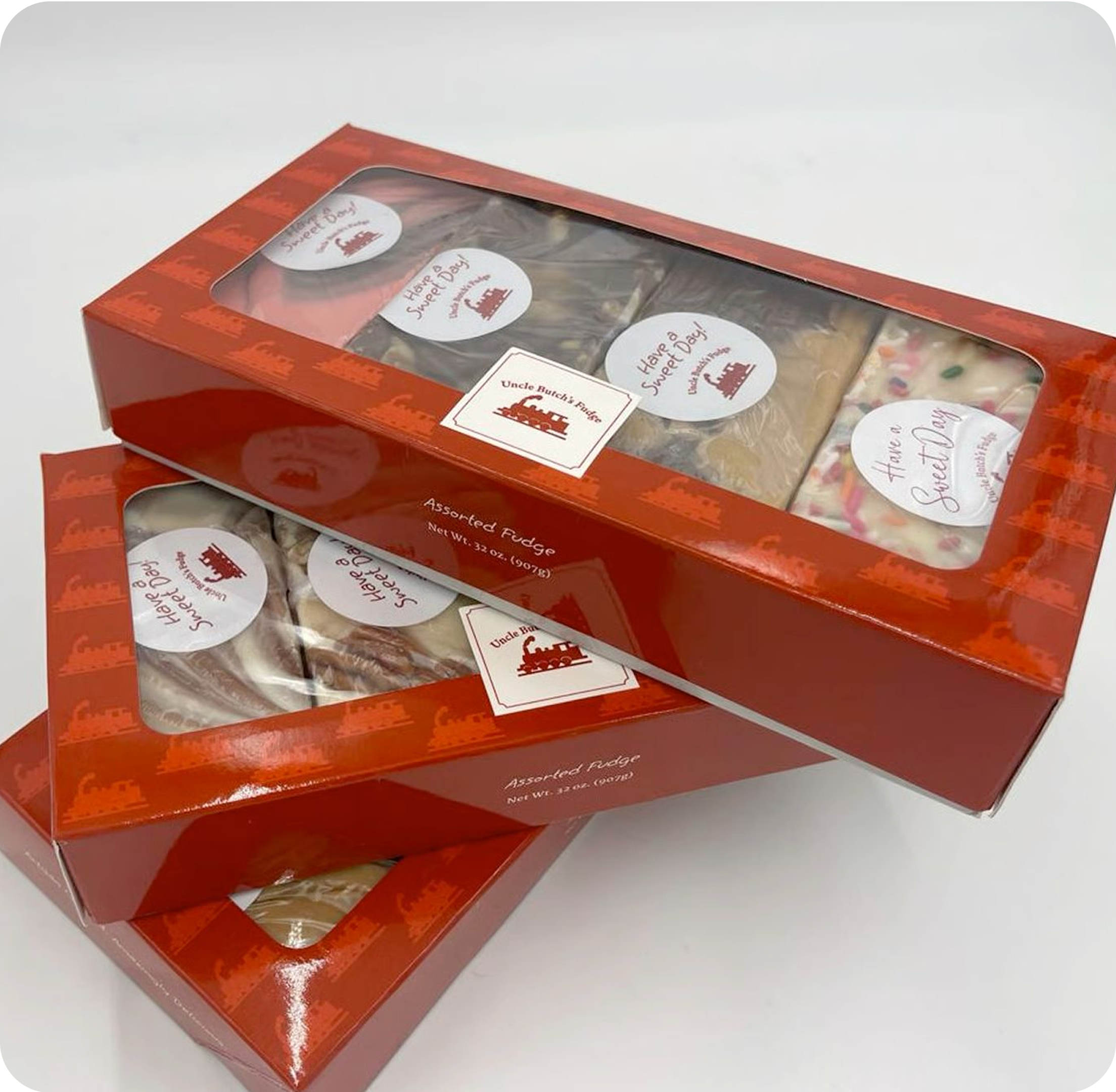 Three red boxes of assorted fudge stacked together.
