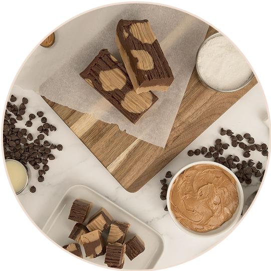 Chocolate peanut butter fudge on a wooden board with ingredients around.