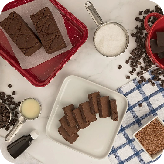 Chocolate fudge with ingredients on a marble countertop.