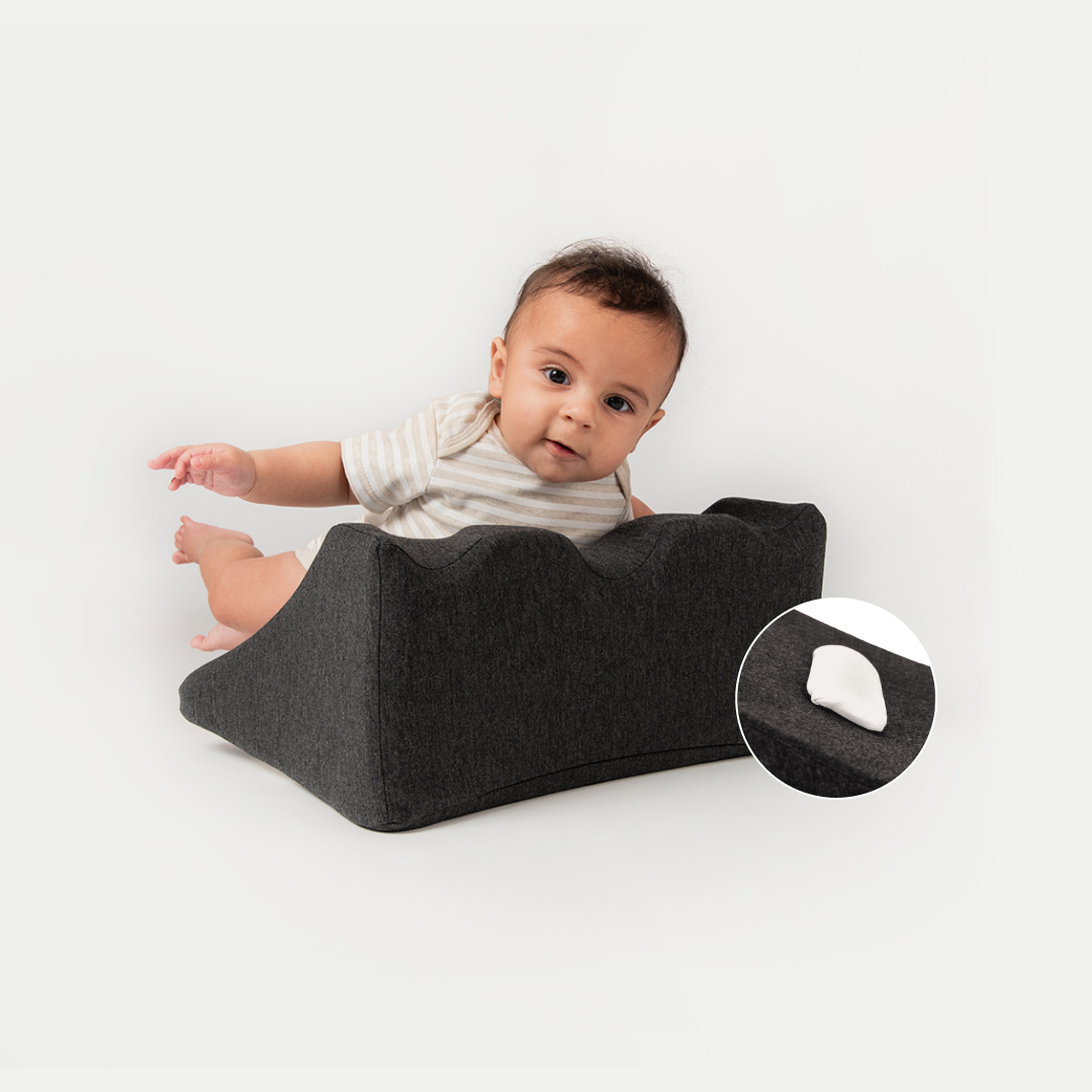 Baby leaning on a dark cushion with an inset showing cushion texture.