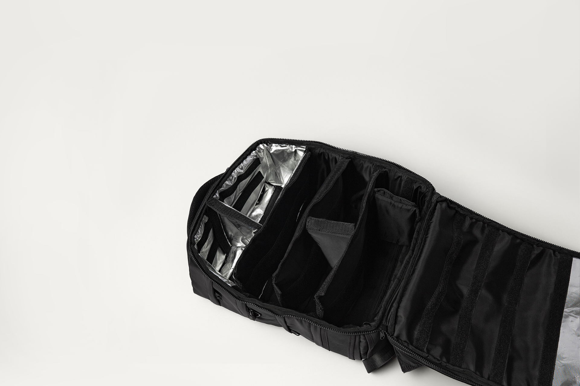 Open black bag with multiple compartments and silver lining.