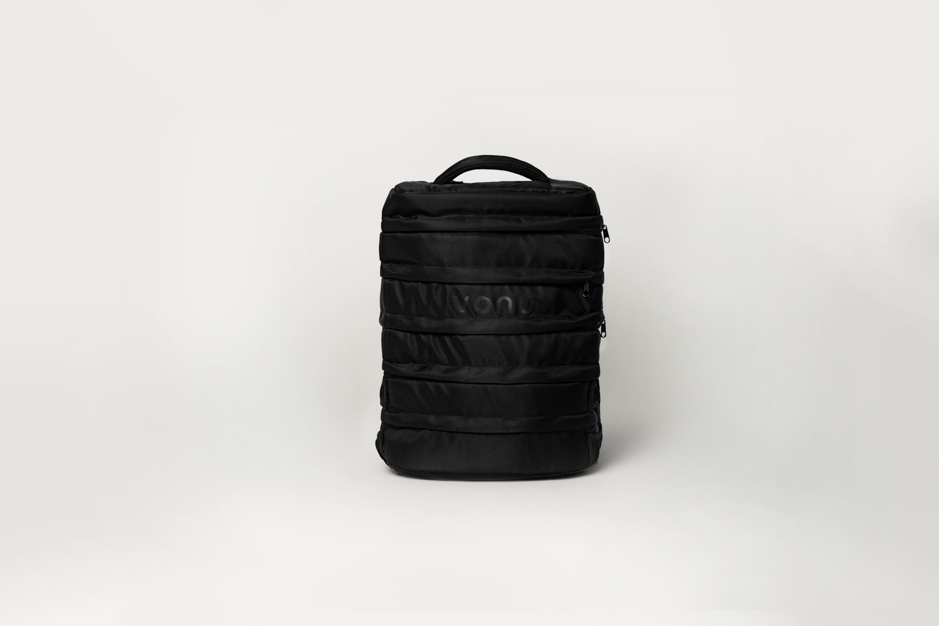Black backpack with multiple zippers on a plain white background.