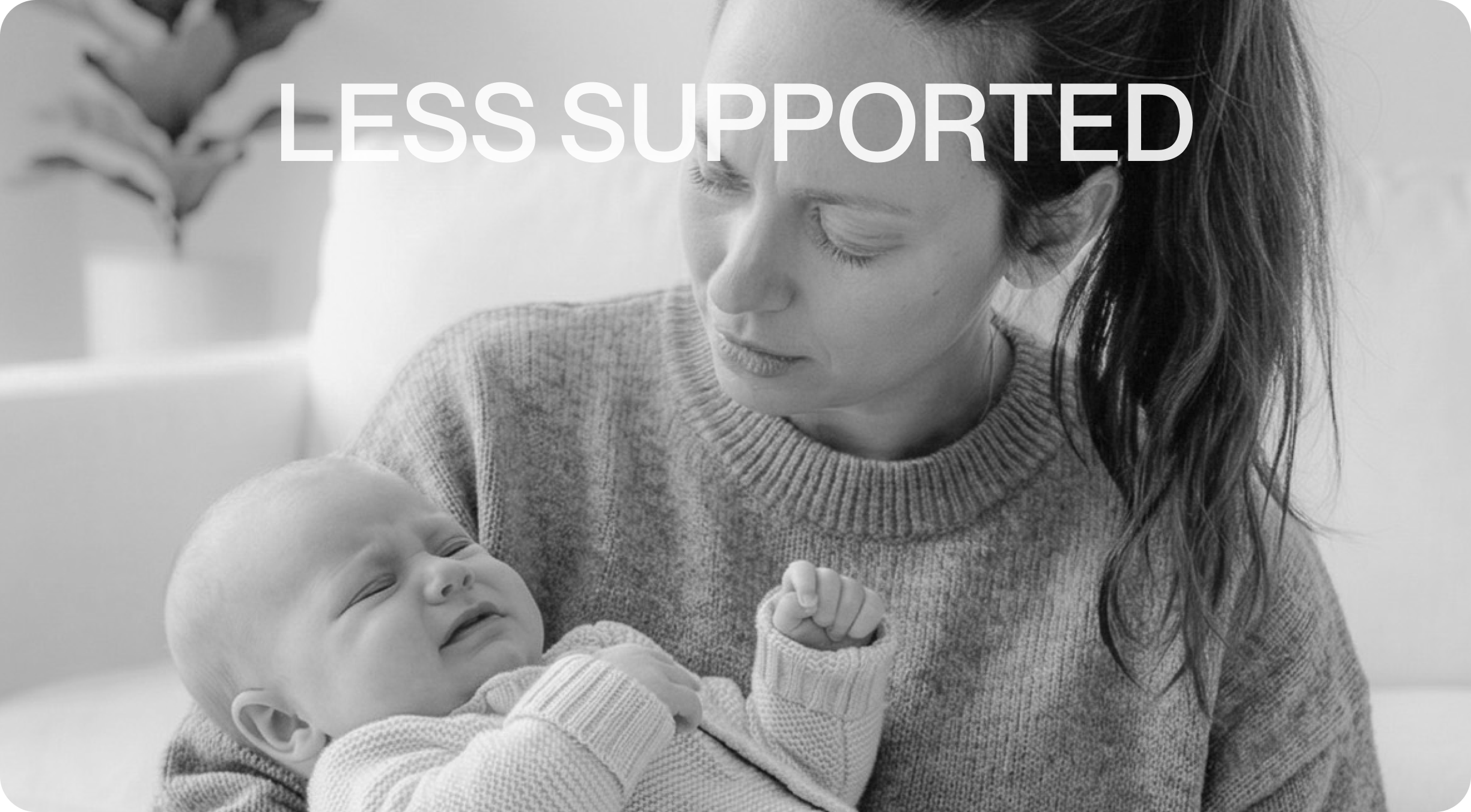A black and white photo of a woman with a worried expression holding a crying baby in a nursery.