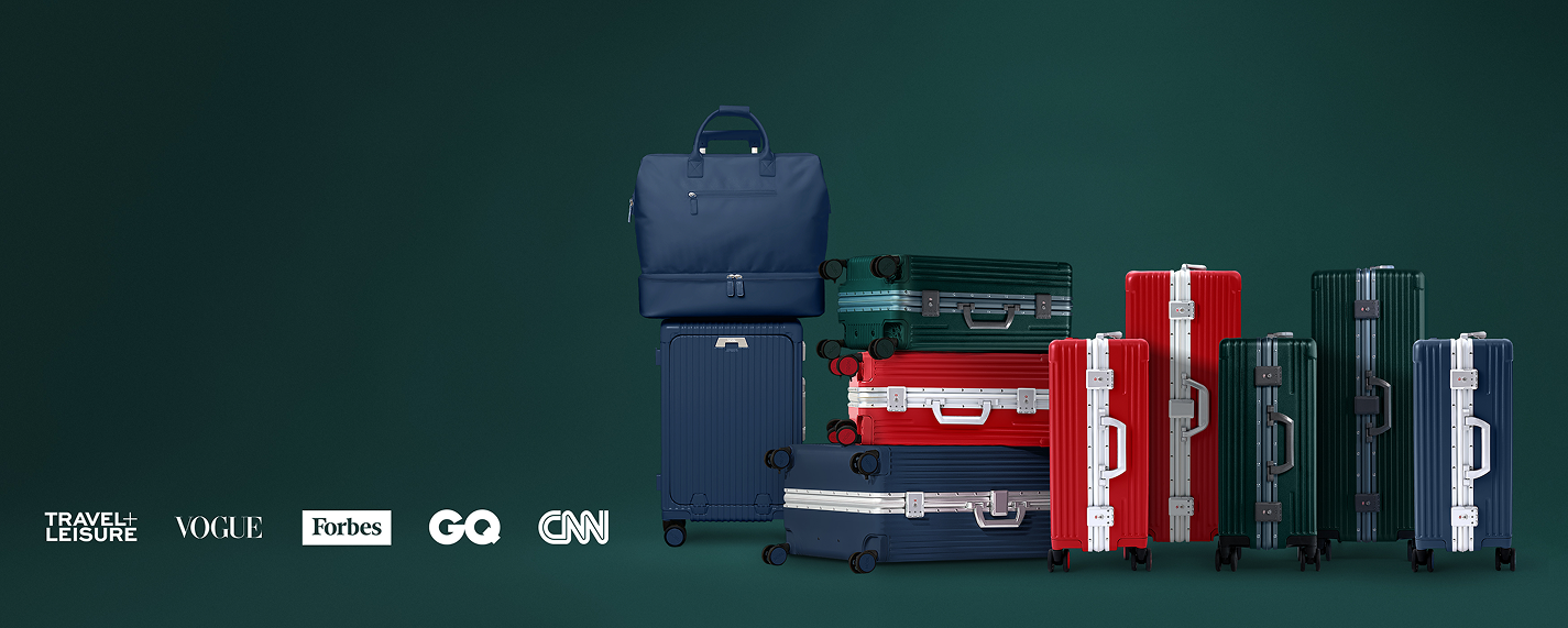 An arrangement of blue, red, and green suitcases and a travel bag against a green background.