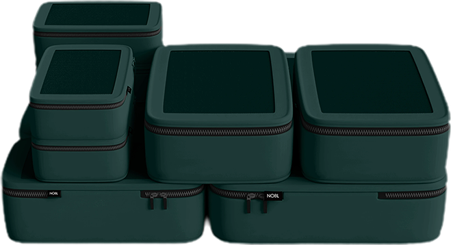 A set of six dark green zippered packing cubes of various sizes against a white background.
