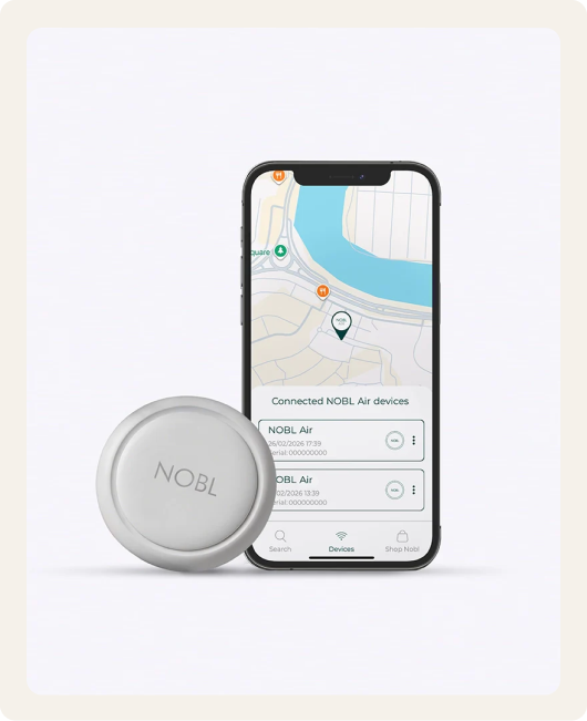 A white NOBL tracking tag next to a smartphone showing the device's location on a map.