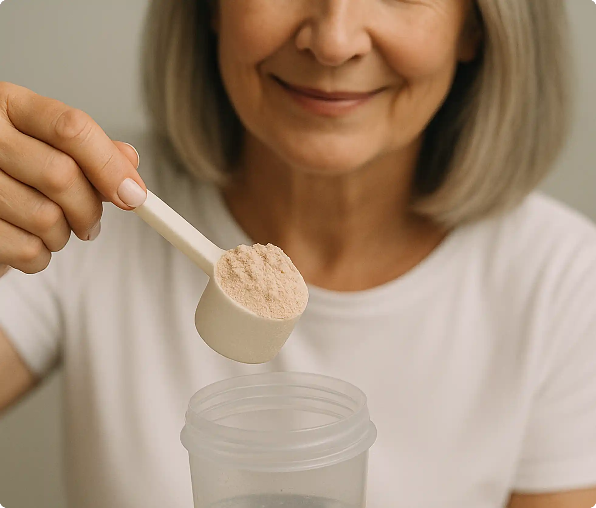 Person holding a scoop of powder above a container.