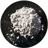 A pile of white powder on a black surface.