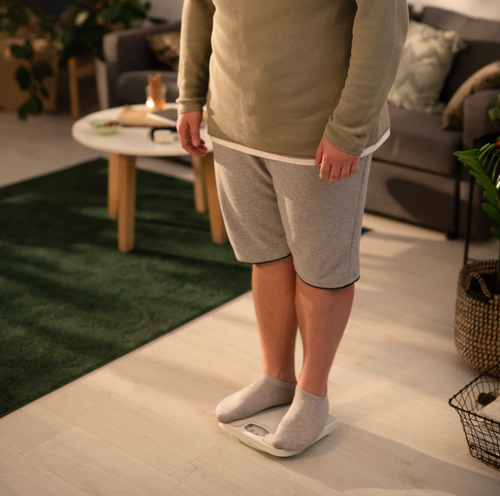 Person standing on a scale in a living room.