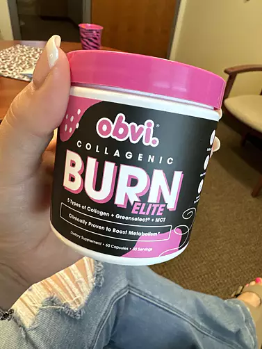 Hand holding a container of Obvi Collagenic Burn Elite supplement.