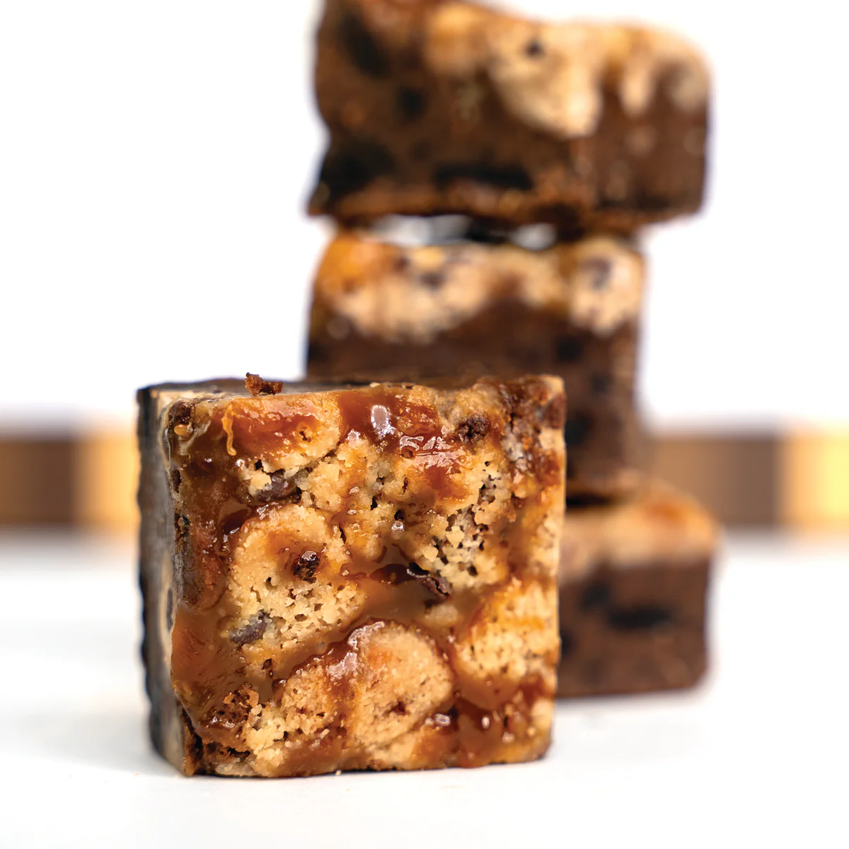 Close-up of a square caramel and chocolate dessert bar.