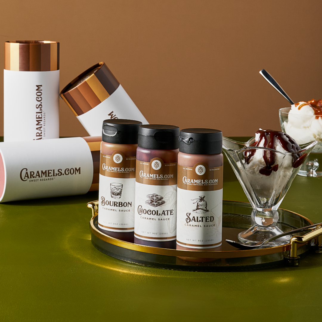 Caramel sauce bottles and ice cream sundae on a green tray.