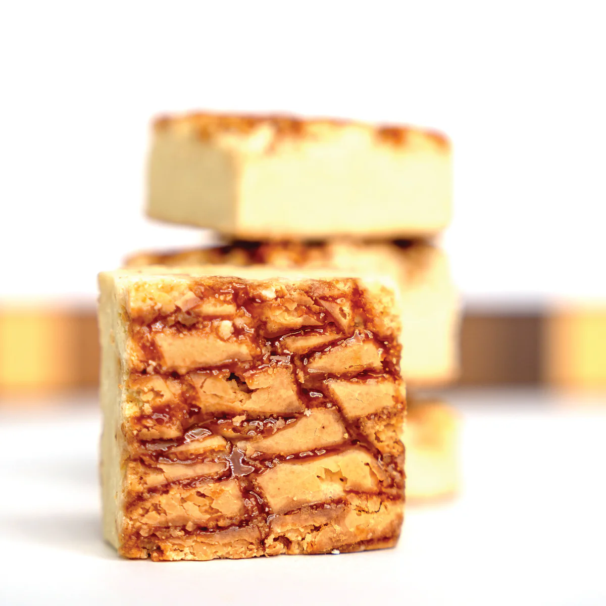 Close-up of caramel-filled cookie bars stacked.