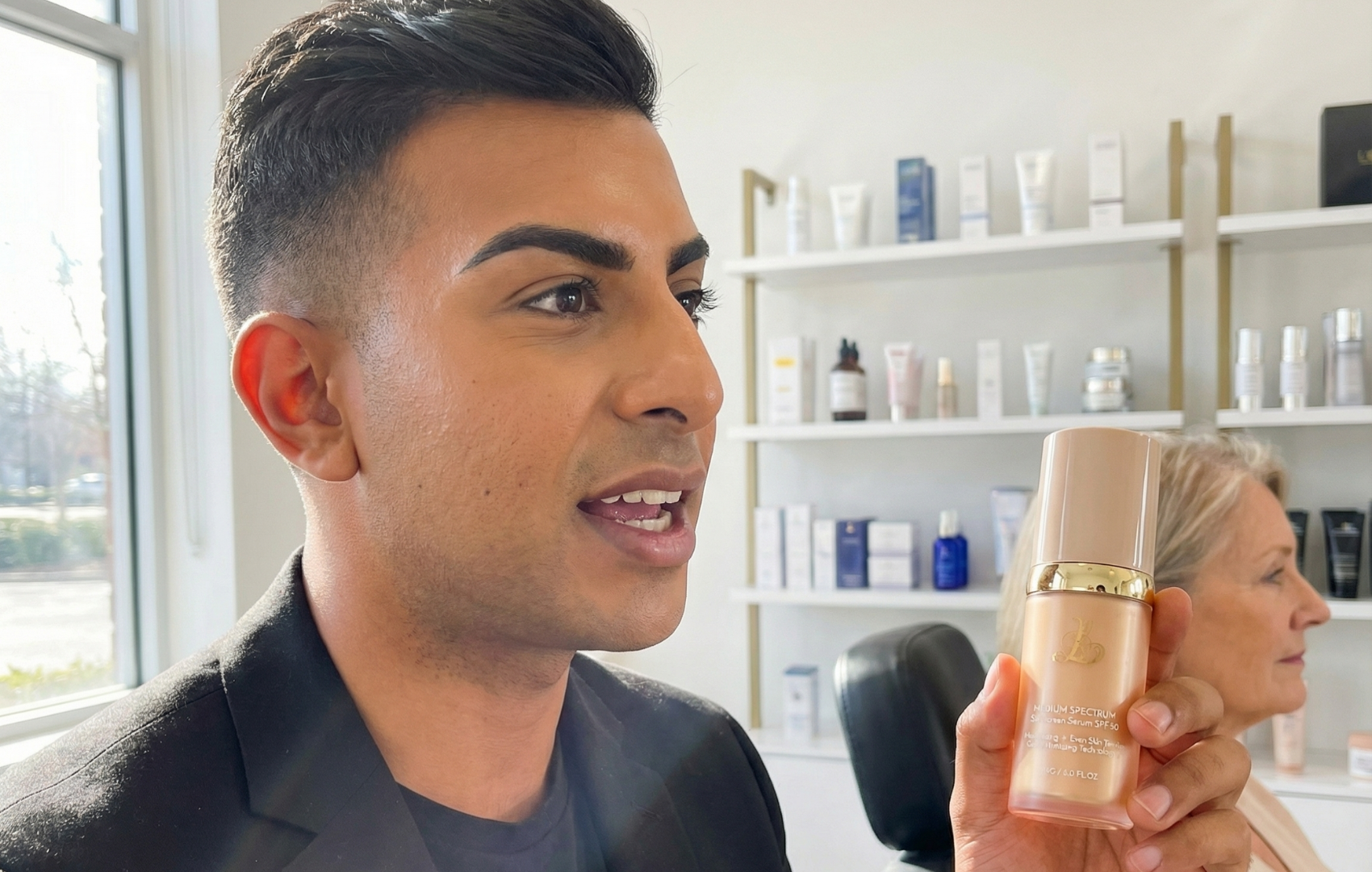 Person holding a bottle of skincare product in a store with shelves in the background.