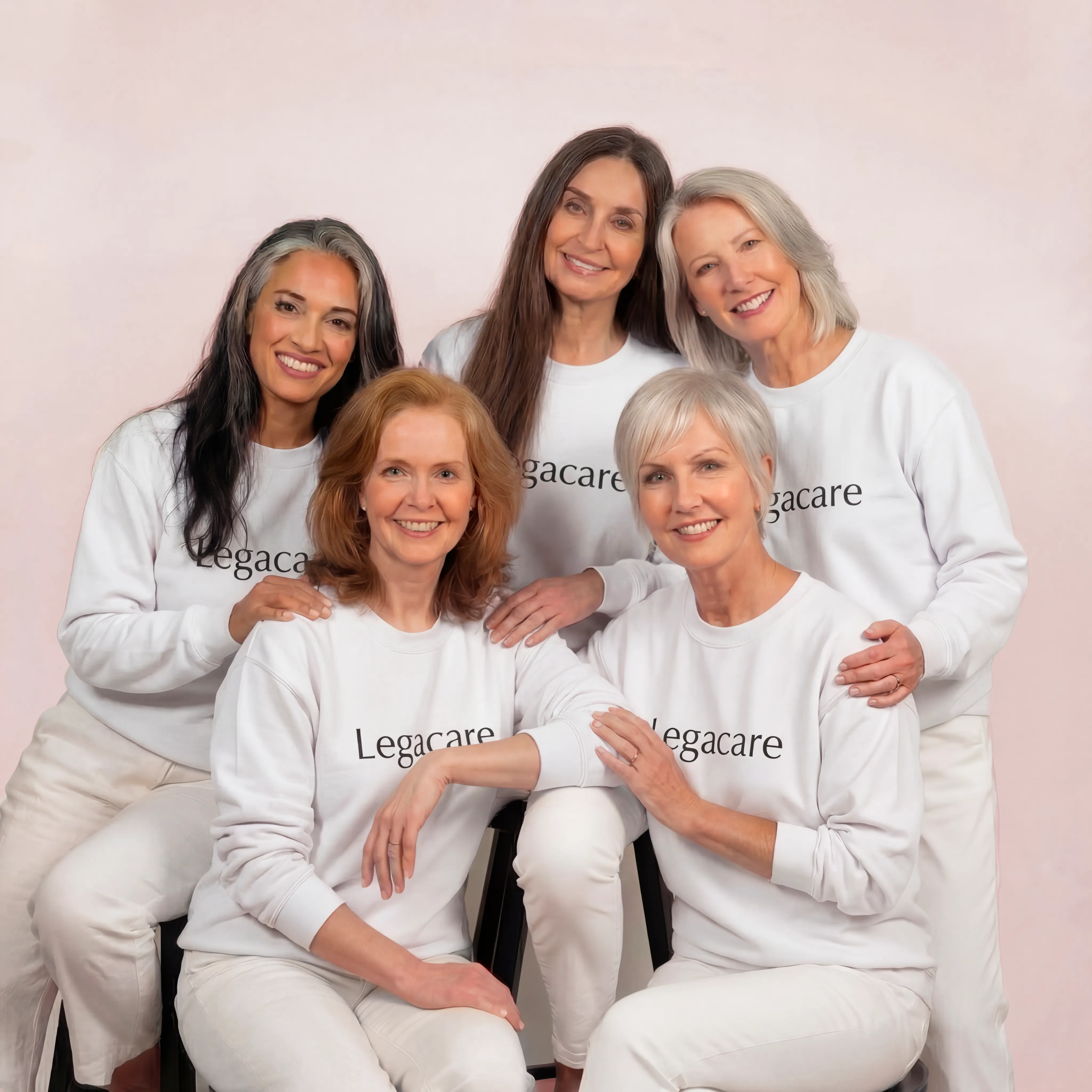 Five women in matching white 'Legacare' shirts, smiling together against a light background.