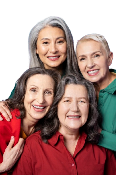 Four smiling women in colorful clothing, posing closely together.
