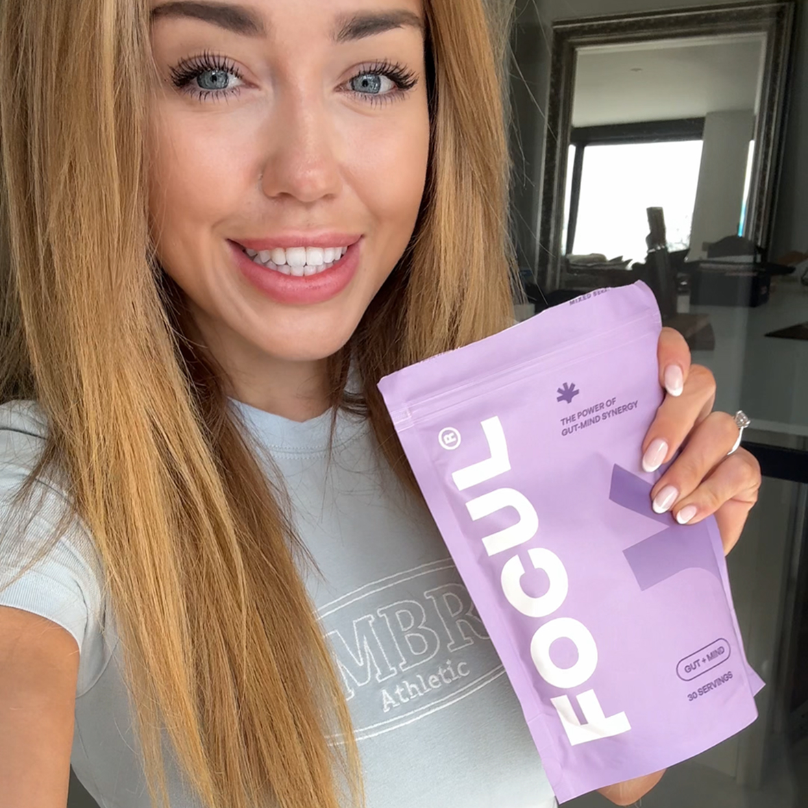 Person holding a purple package labeled 'FOCUL' with a smile.