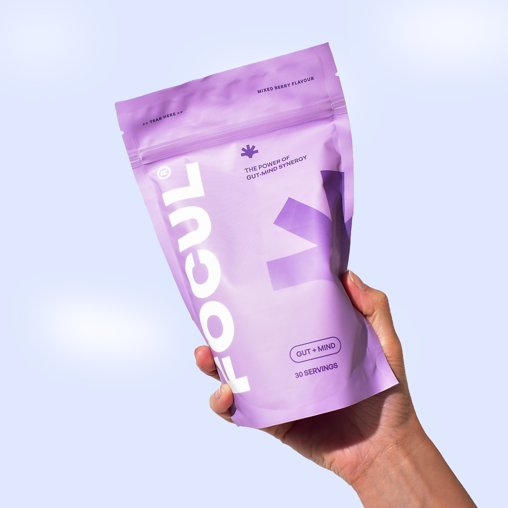 A hand holding a purple package labeled 'FOCUL' with gut-mind synergy text.