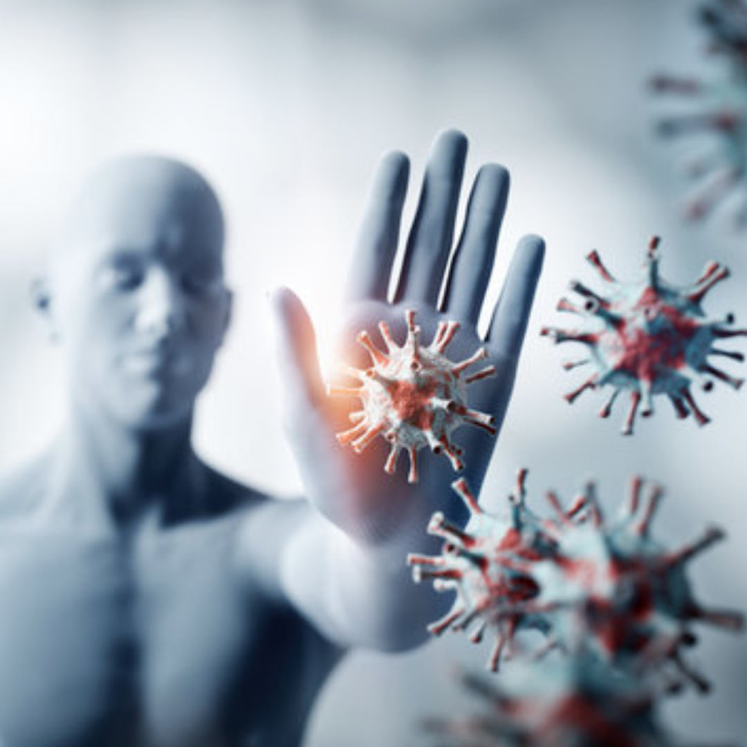 Silhouetted figure with hand raised against floating virus-like particles.