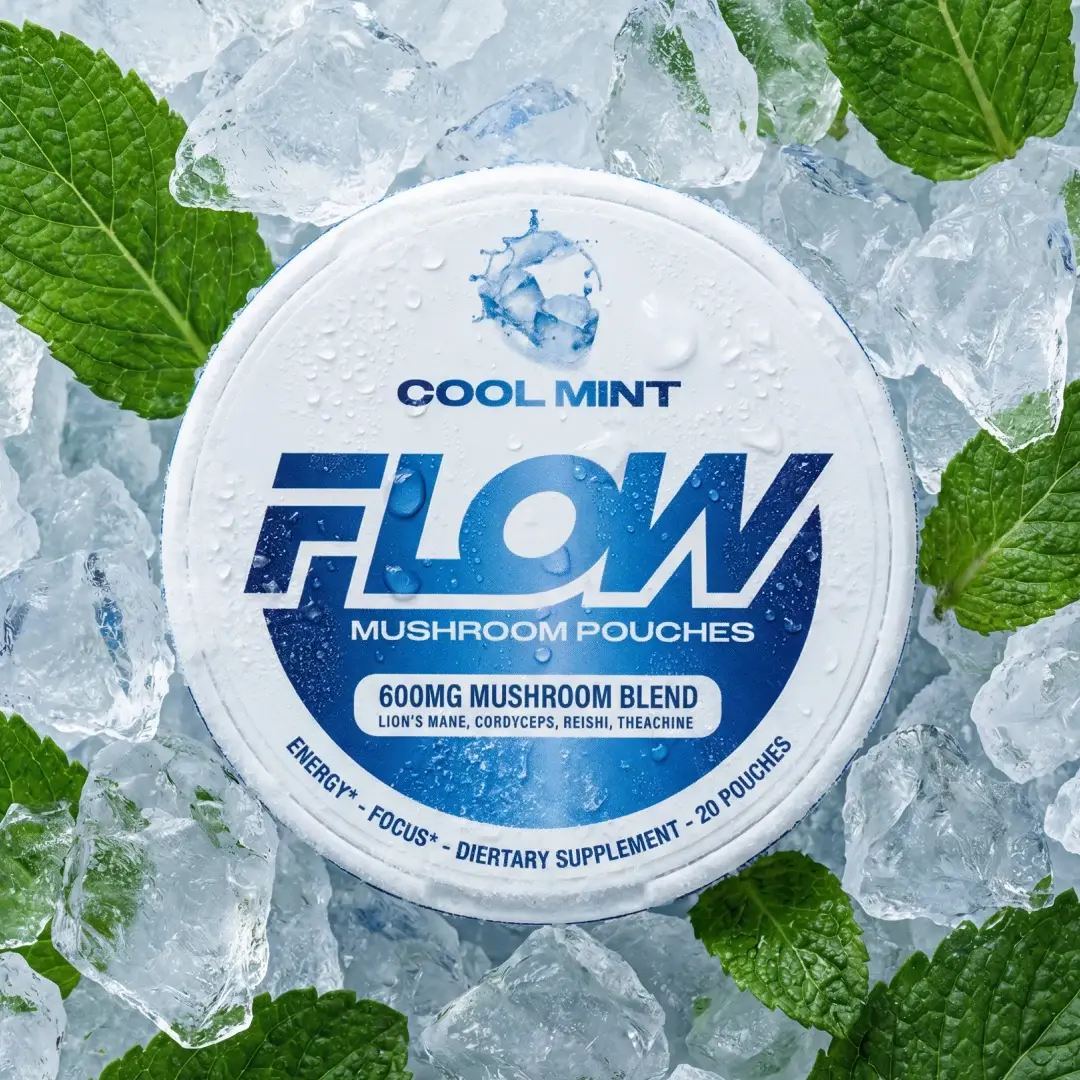 A white circular container of Flow Cool Mint mushroom pouches sitting on ice cubes with fresh mint leaves.