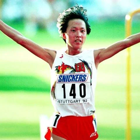 Athlete with arms raised, wearing number 140, at an event labeled Stuttgart '93.
