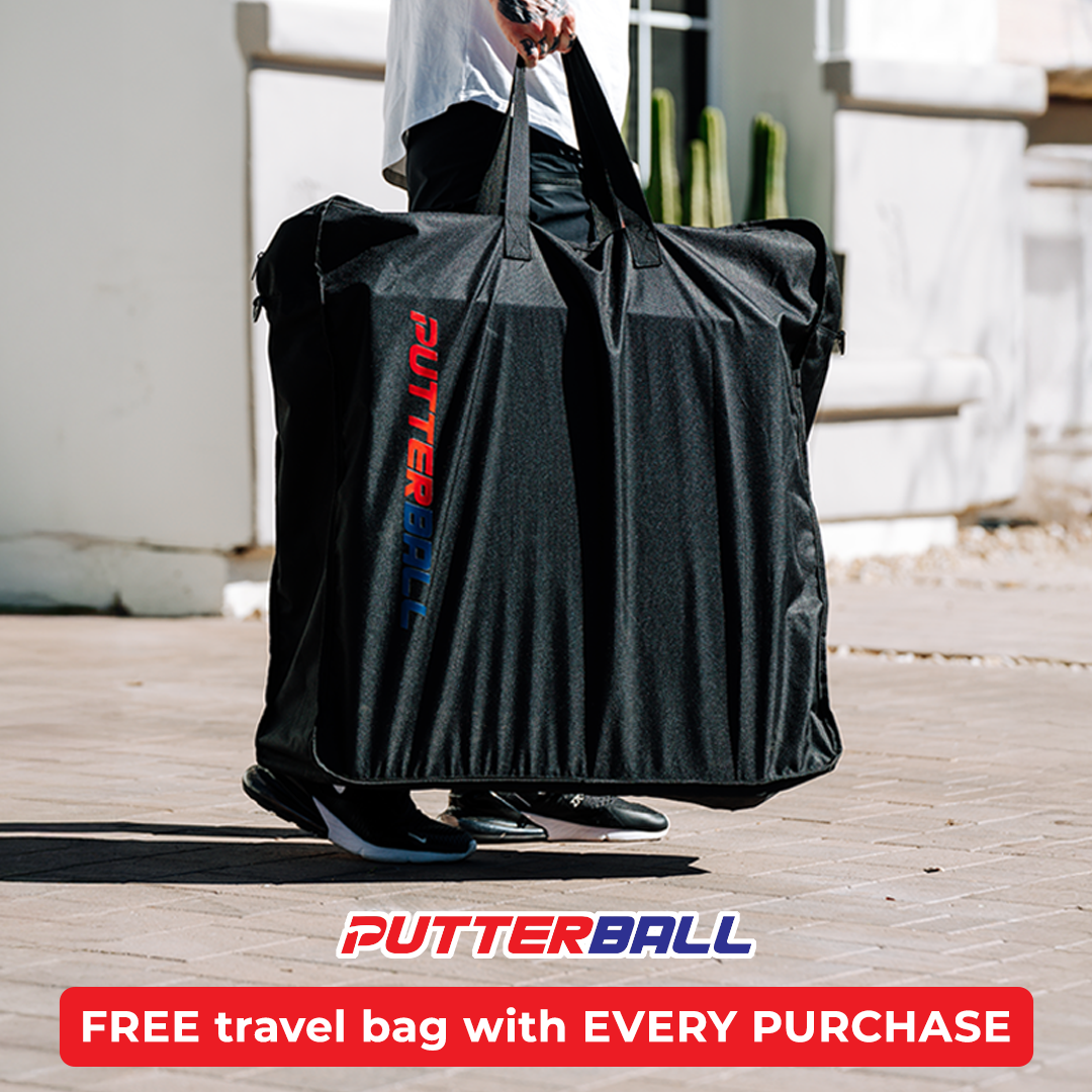 Person carrying a large black PutterBall bag outdoors.
