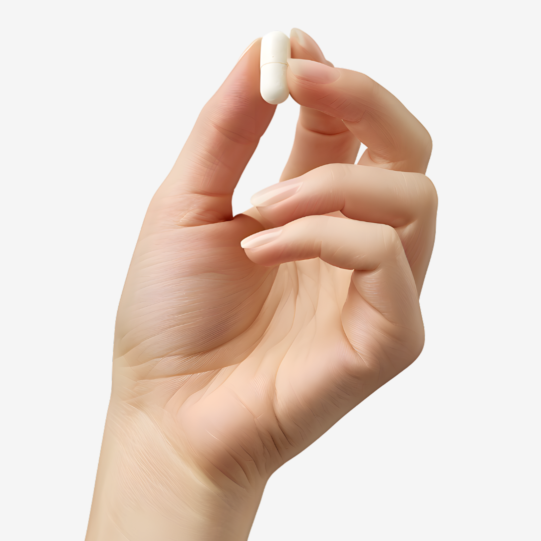 Hand holding a small white capsule between fingers.