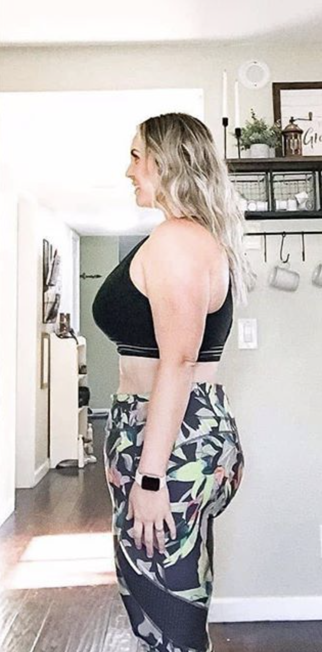 Person in workout attire standing sideways in a room.