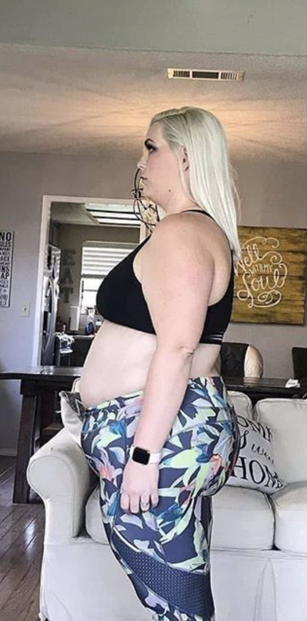 Person in workout attire standing in a living room.