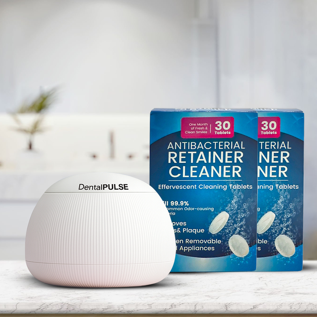 A white DentalPULSE cleaning device sits on a counter next to two boxes of antibacterial retainer cleaner tablets.