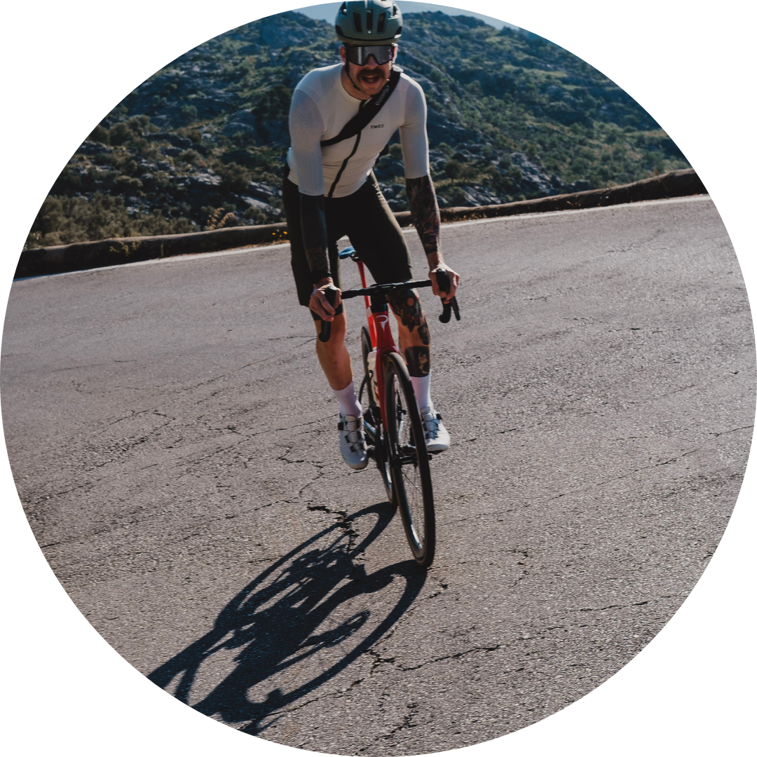 Cyclist riding on a mountain road with scenic background.