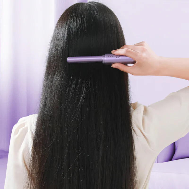 Person brushing long, straight black hair with a purple hairbrush.