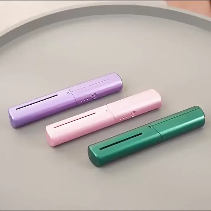 Three electronic devices in purple, pink, and green are arranged diagonally on a grey circular tray.