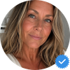 A circular profile photo of a woman with long, wavy hair and a blue verification checkmark.