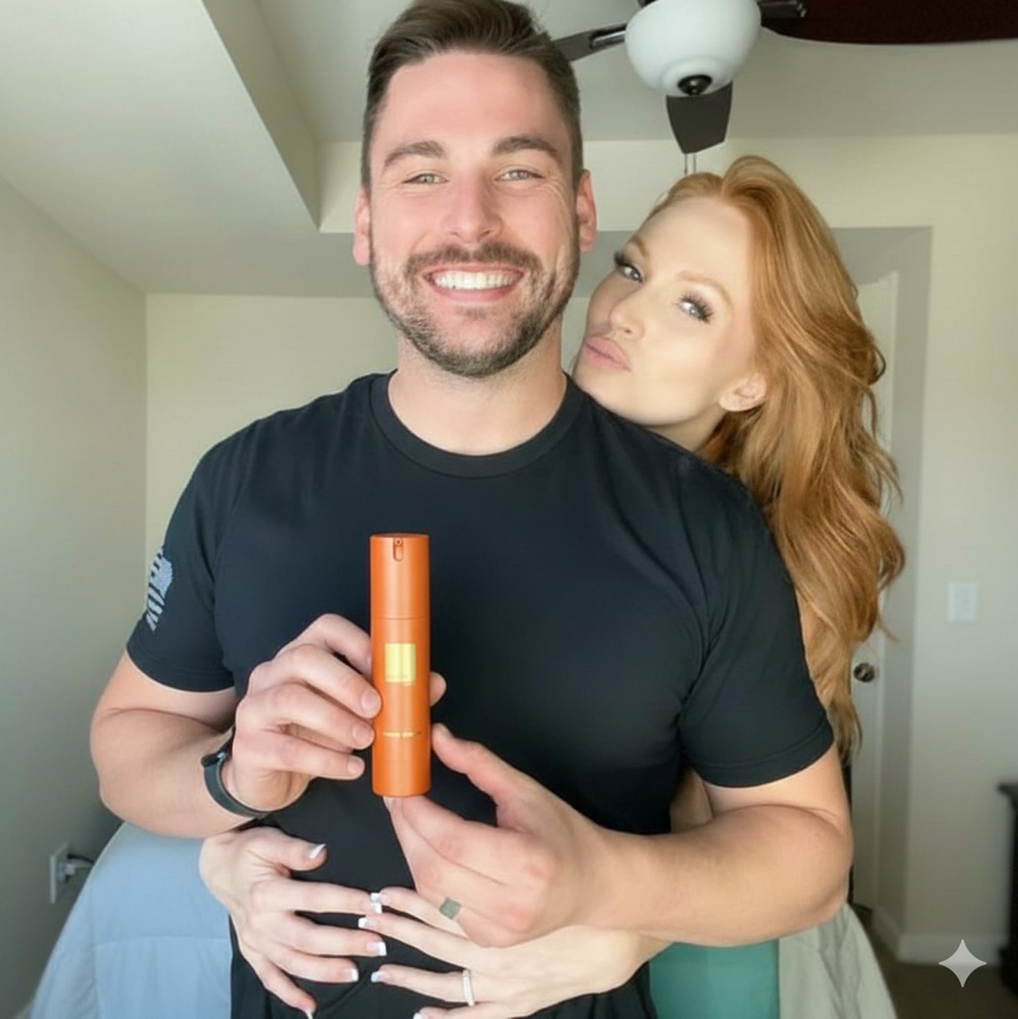 Man and woman smiling, holding an orange spray bottle.