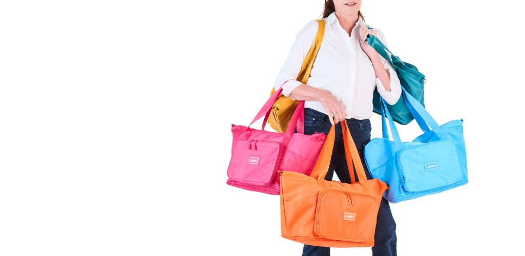 Person carrying multiple colorful tote bags against a white background.