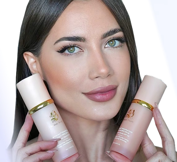 A woman with dark hair and makeup holds up two bottles of cosmetic serum.