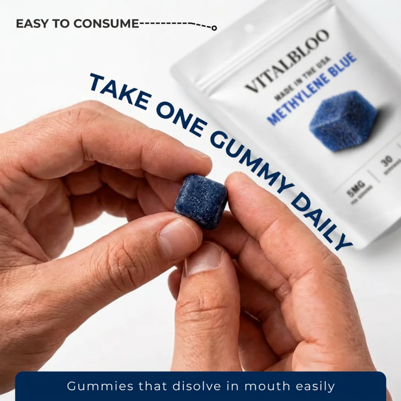 A person holds a blue, cube-shaped gummy with the Vitalbloo Methylene Blue supplement pouch in the background.