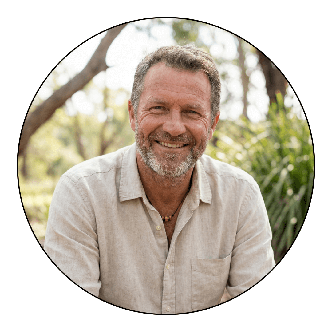 A circular portrait of a smiling, middle-aged man with a beard, wearing a casual shirt outdoors.