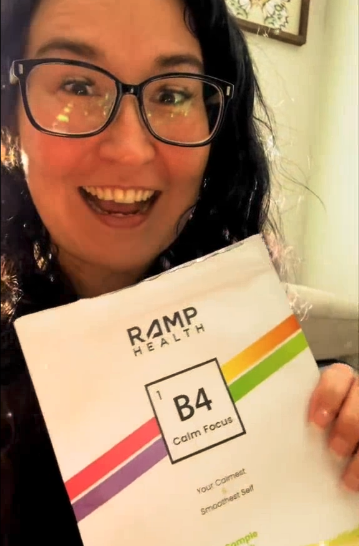 Person smiling, holding a Ramp Health B4 Calm Focus packet.