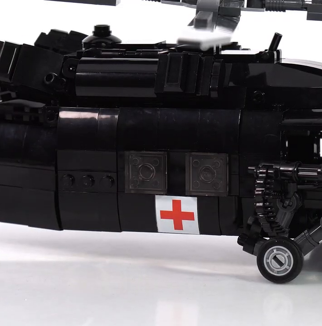 A close-up of a black toy medical helicopter made from plastic building blocks against a white background.