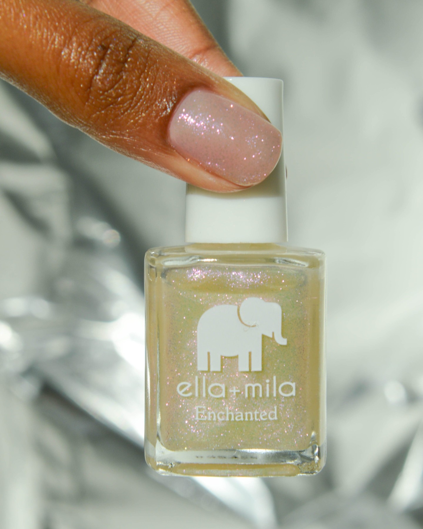 Hand holding a bottle of ella+mila Enchanted nail polish.