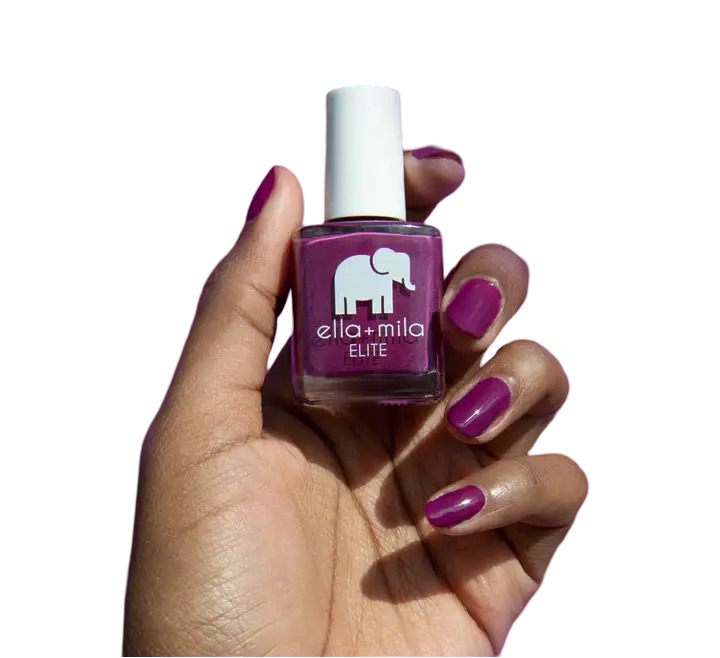 Hand holding a bottle of purple nail polish with matching painted nails.