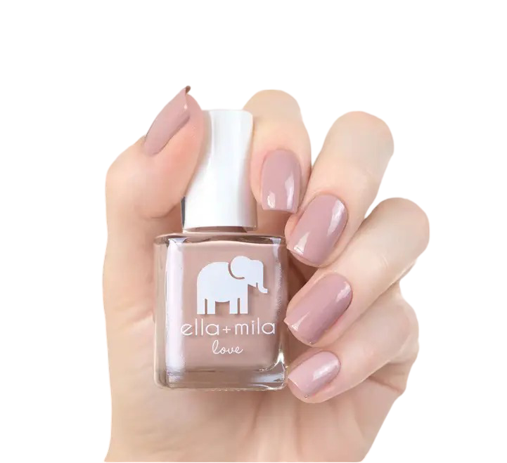 Hand holding a bottle of nude nail polish with painted nails.